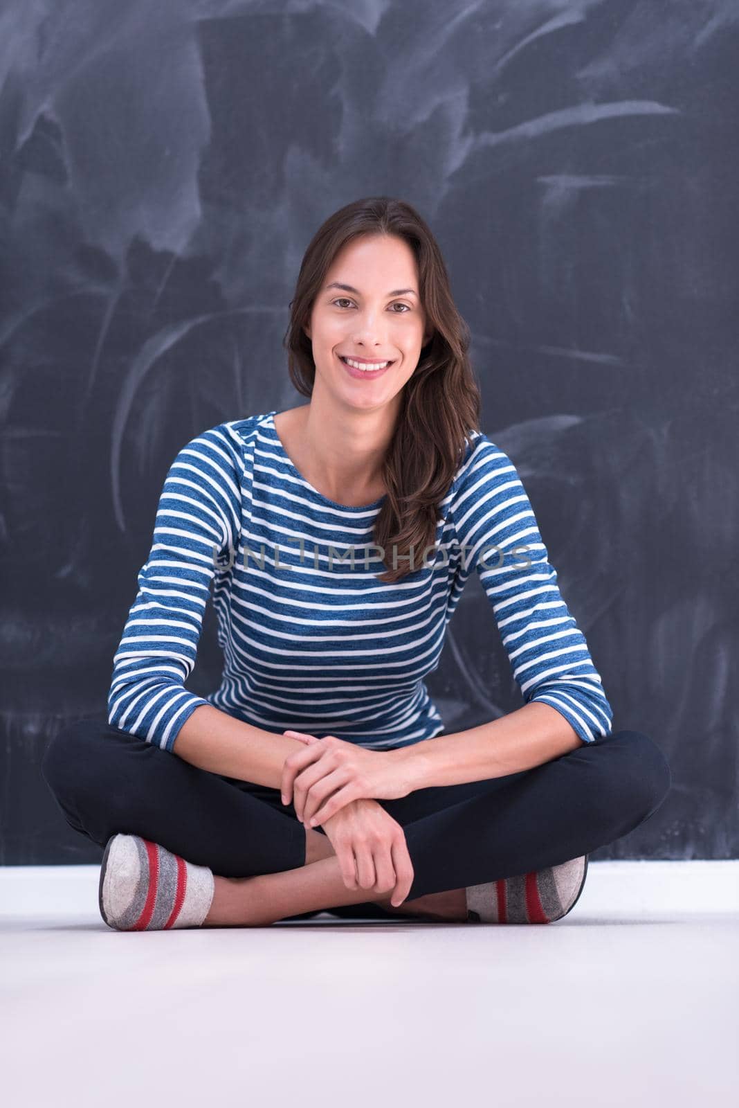 portrait of a young woman sitting in front of chalk drawing board