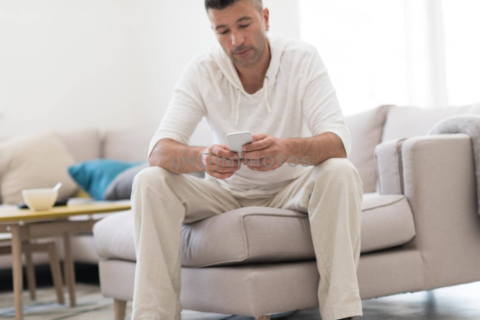 young man using a mobile phone  at home by dotshock