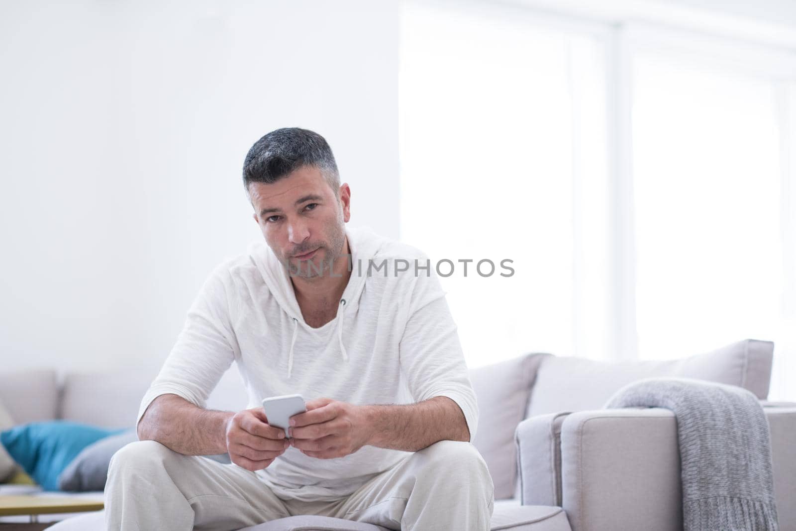 Handsome casual young man using a mobile phone at luxurious home