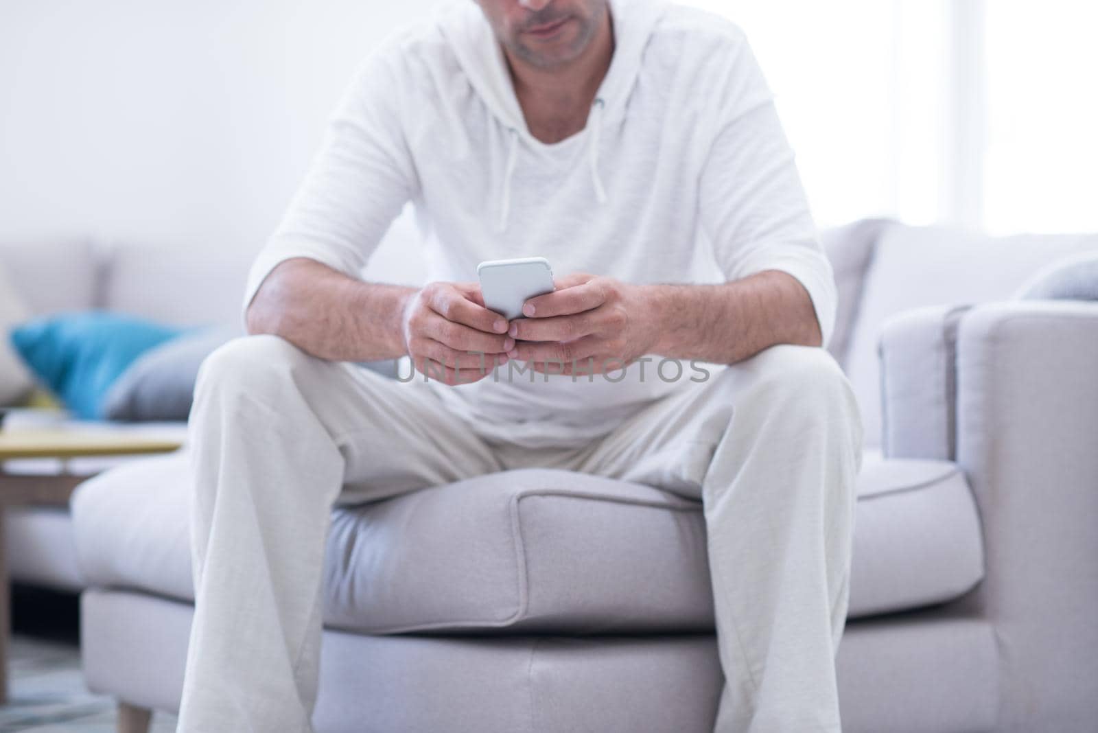 young man using a mobile phone  at home by dotshock