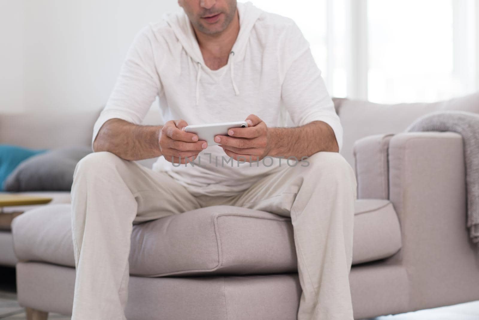 young man using a mobile phone  at home by dotshock