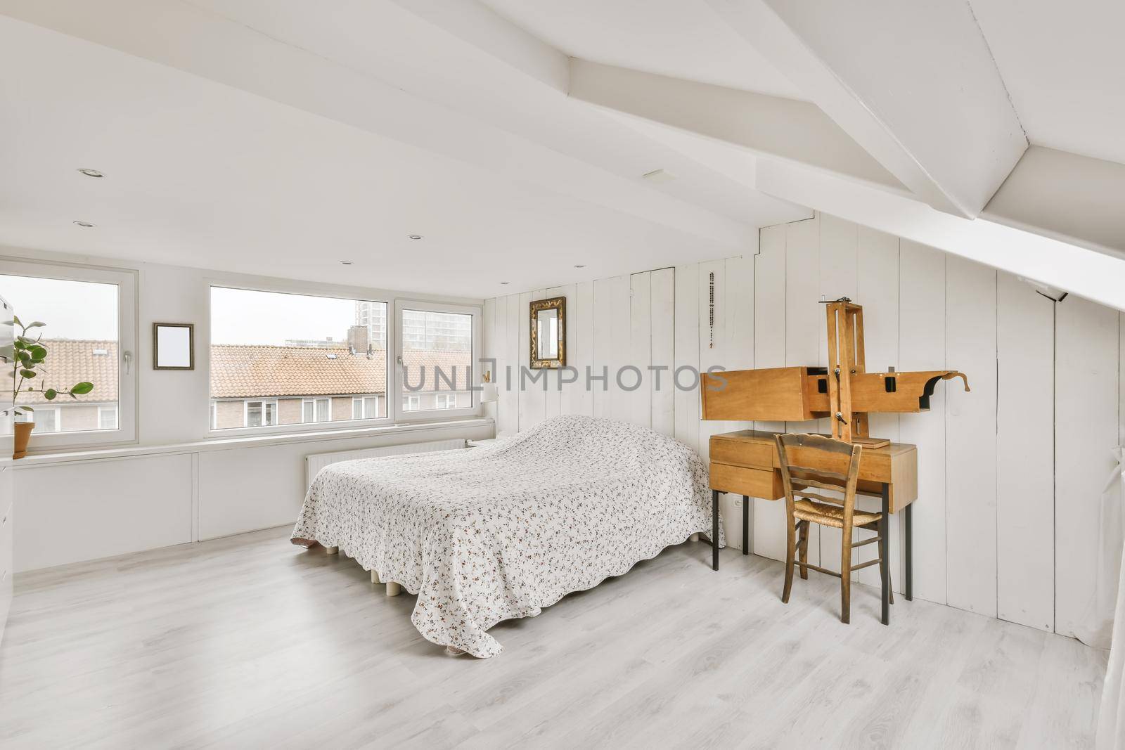 Cozy attic room with a fluffy bed covered with a blanket
