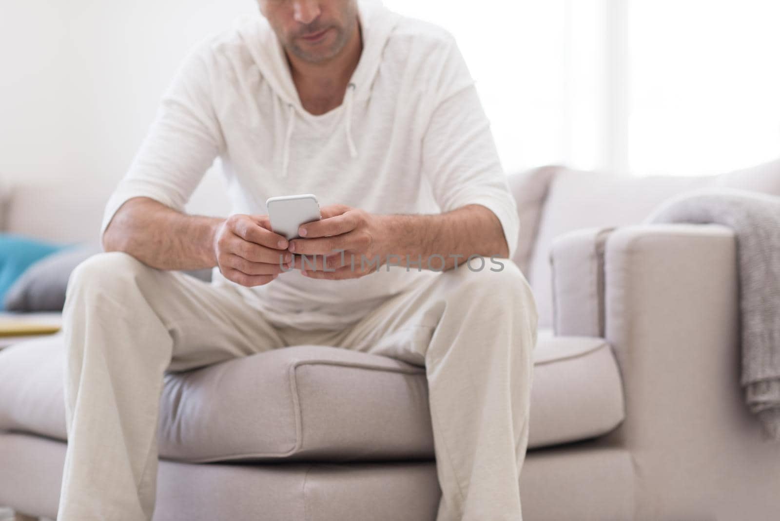 Handsome casual young man using a mobile phone at luxurious home