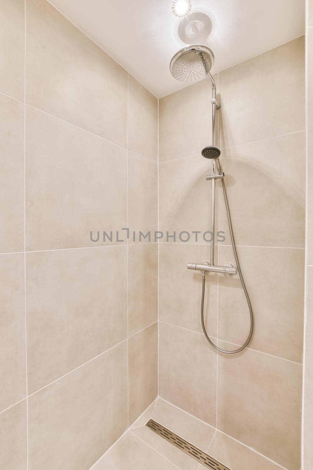 Beige bathroom with modern walk-in shower in a luxury apartment
