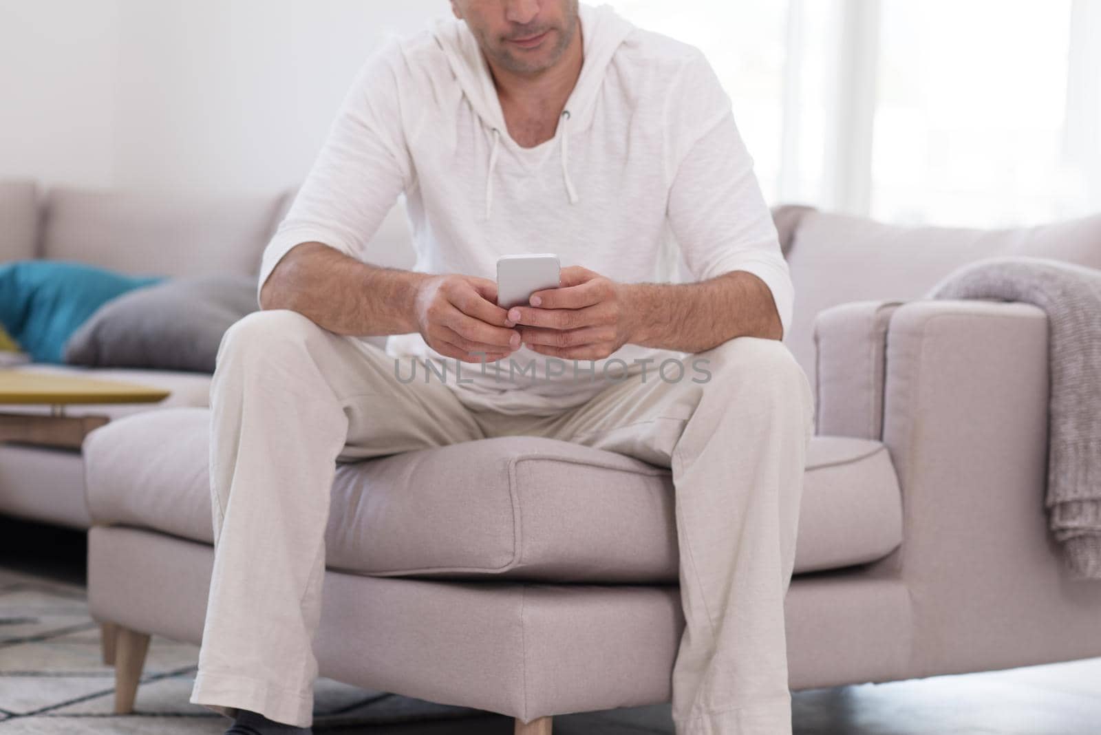 young man using a mobile phone  at home by dotshock