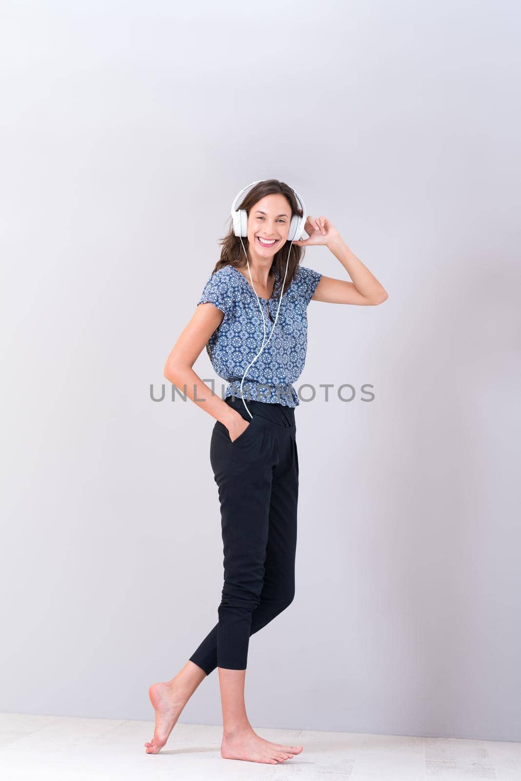 Happy young woman listening and enjoying music with headphones isolated on a white background