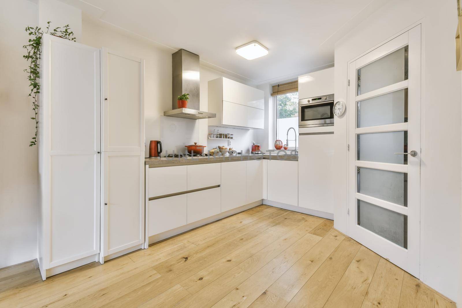 Cozy daylight kitchen with white cabinets and hardwood floors