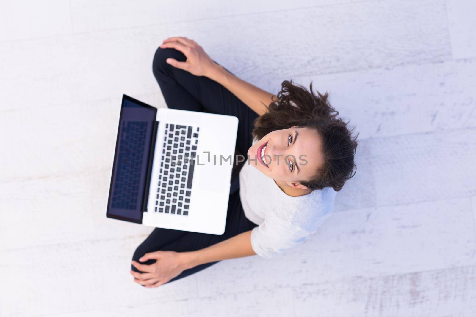 top view of a beautiful young women using laptop computer on the floor at home