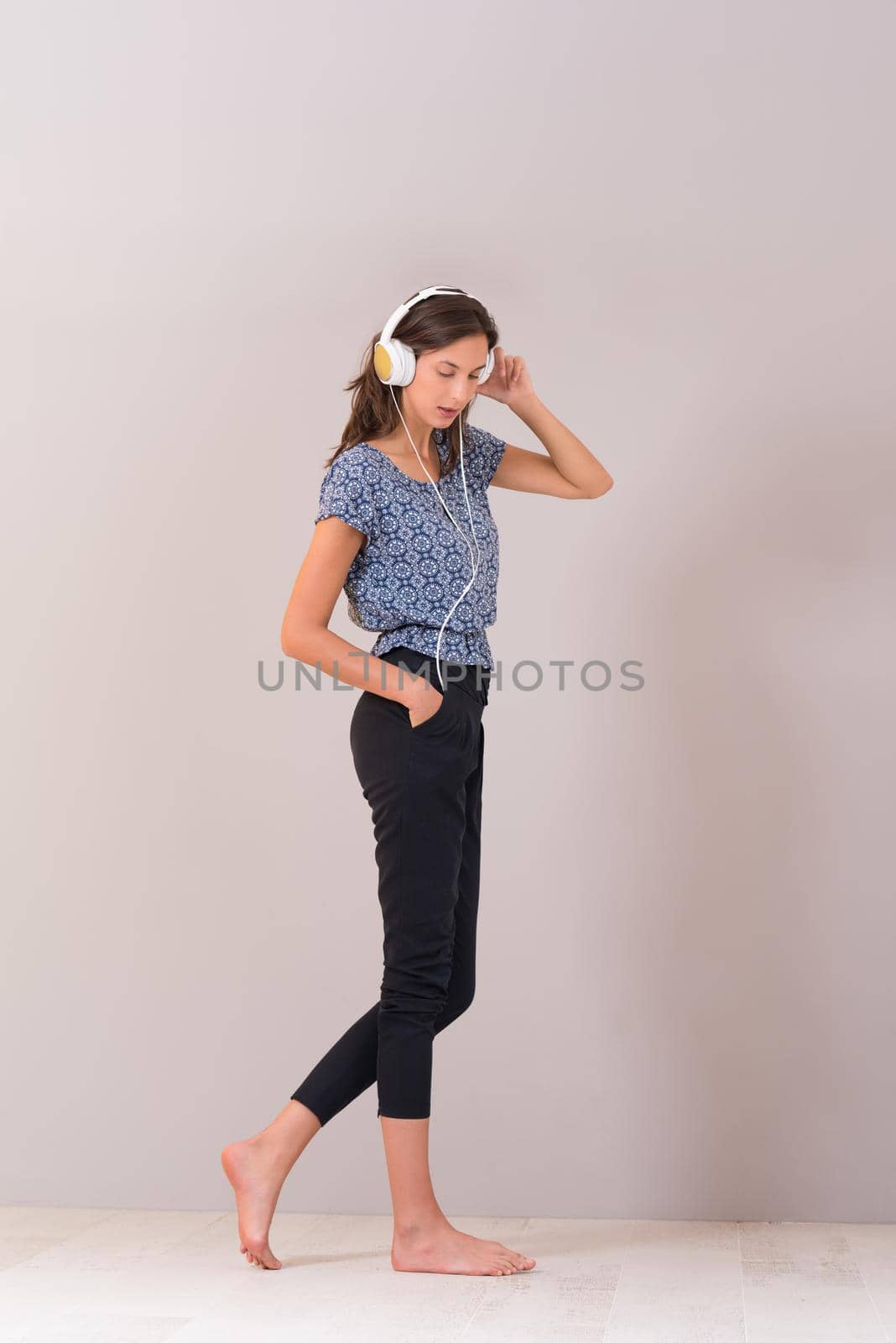 Happy young woman listening and enjoying music with headphones isolated on a white background