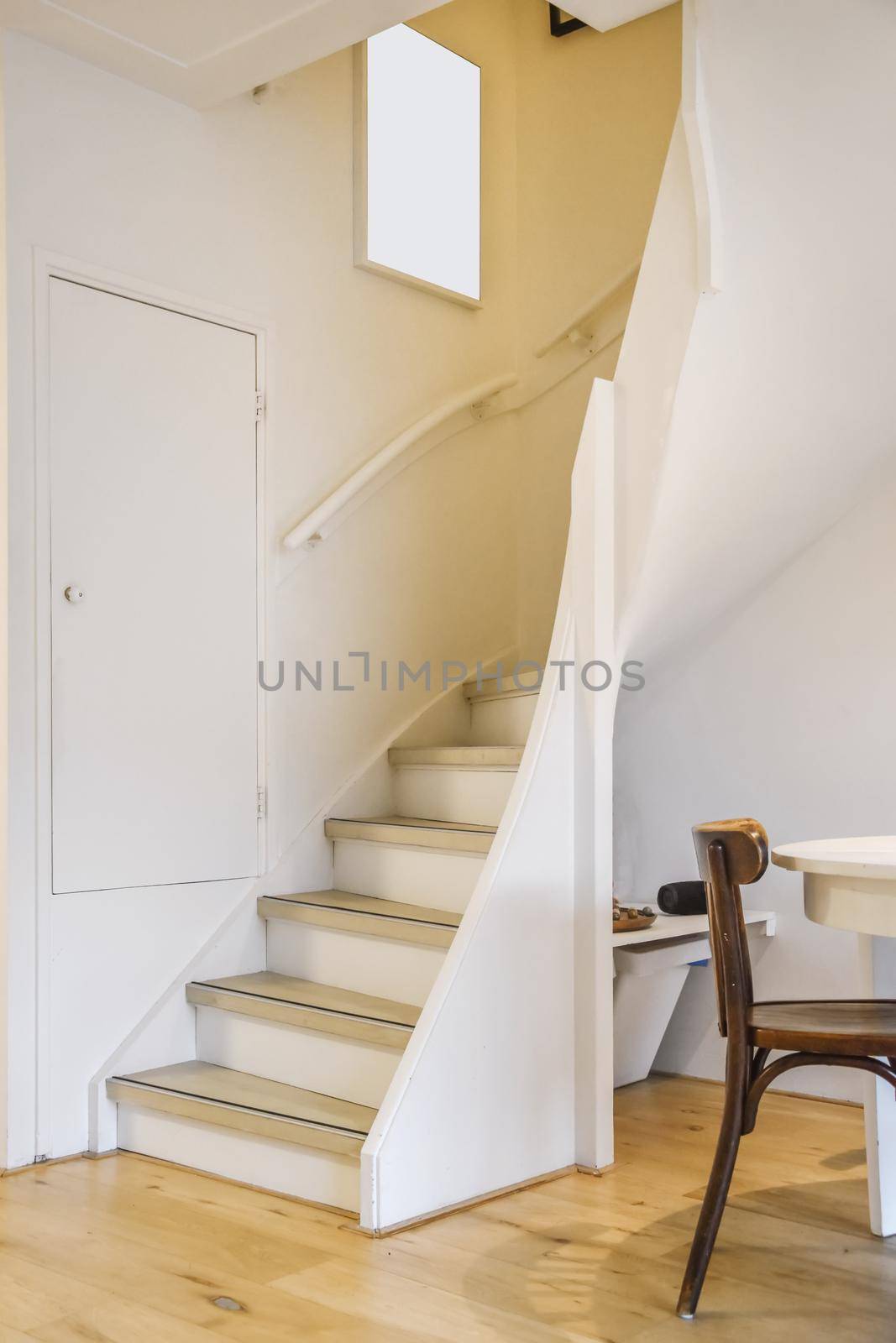 Cozy spiral white staircase with a painting on the wall