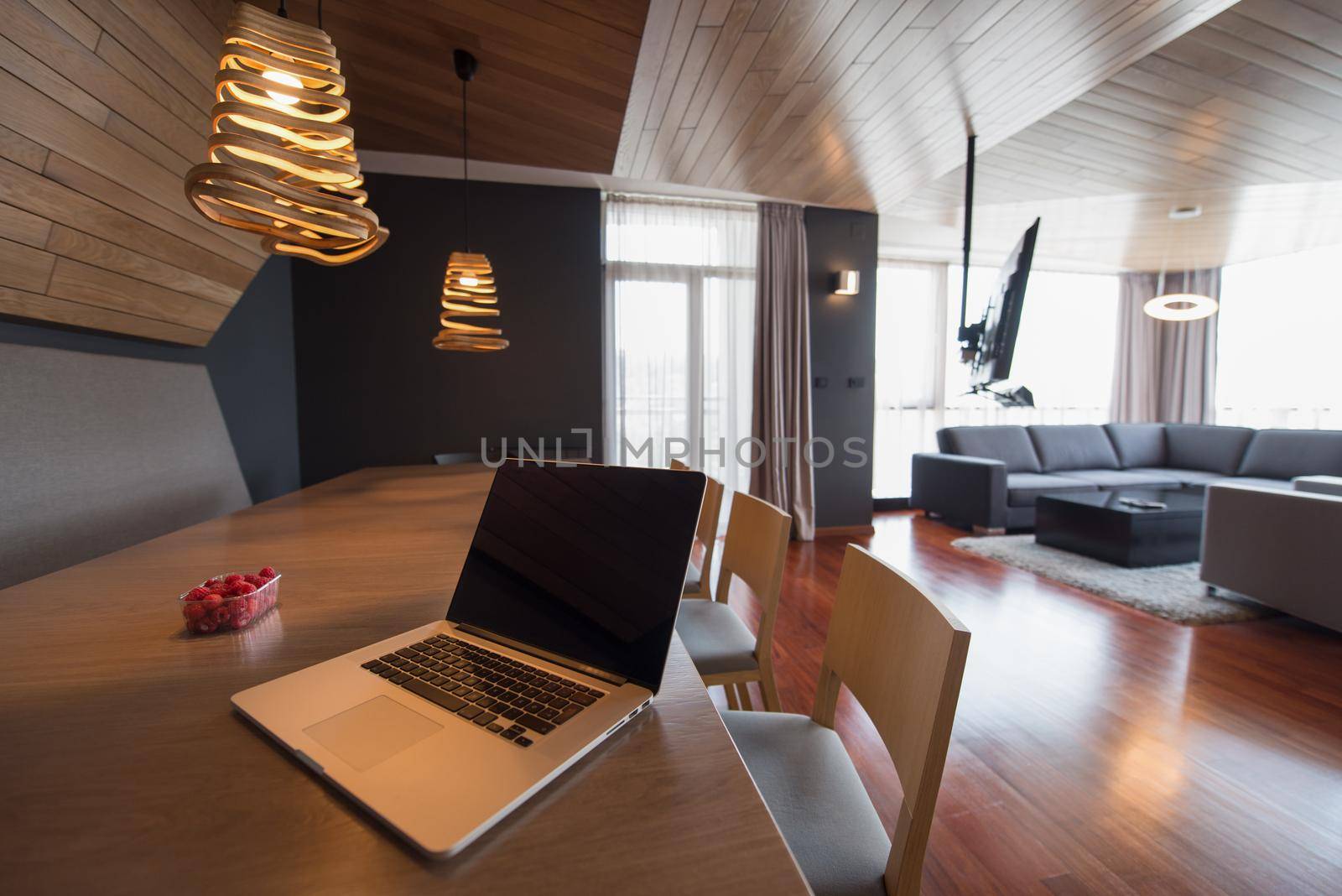 Notebook with blank screen on table in luxury living room.