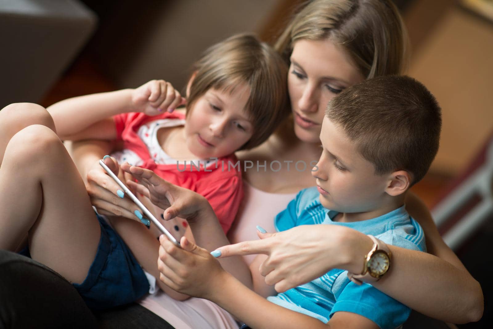 Happy Family Lying Down On The Sofa And Using Tablet