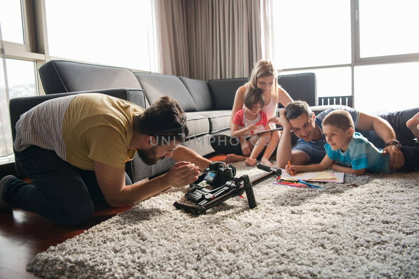 Happy Young Family Playing Together at home on the floor using a tablet and a children's drawing set