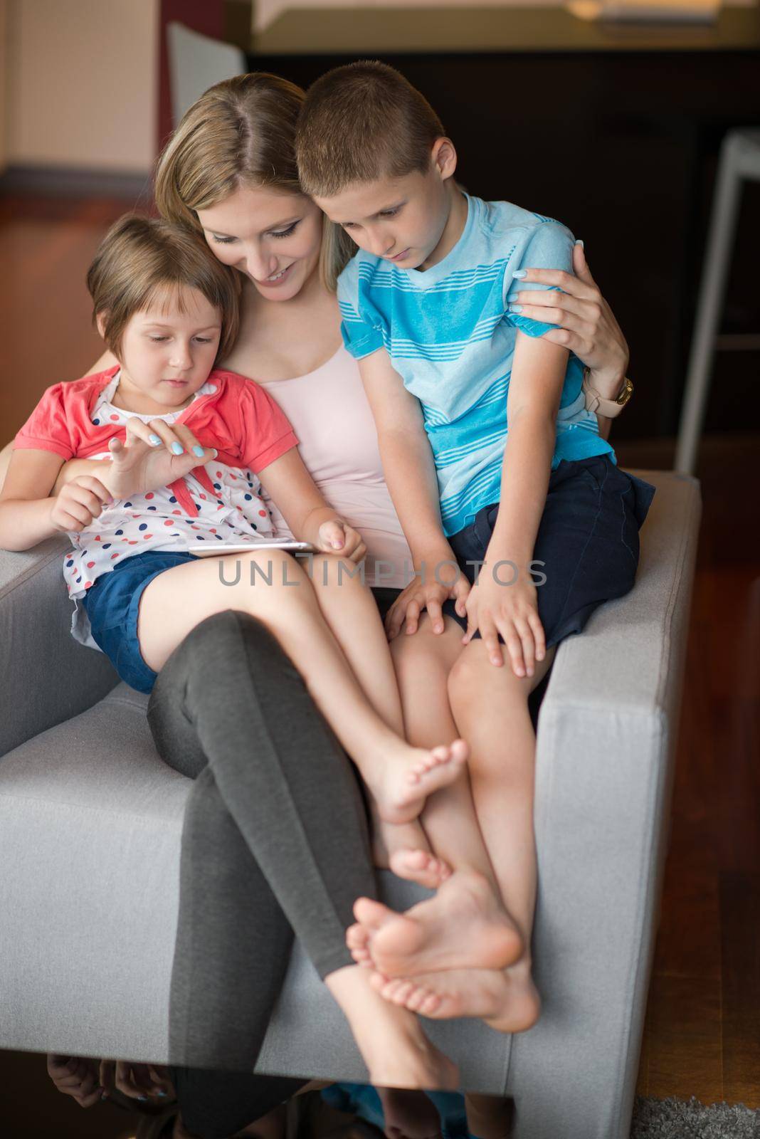 Happy Family Lying Down On The Sofa And Using Tablet