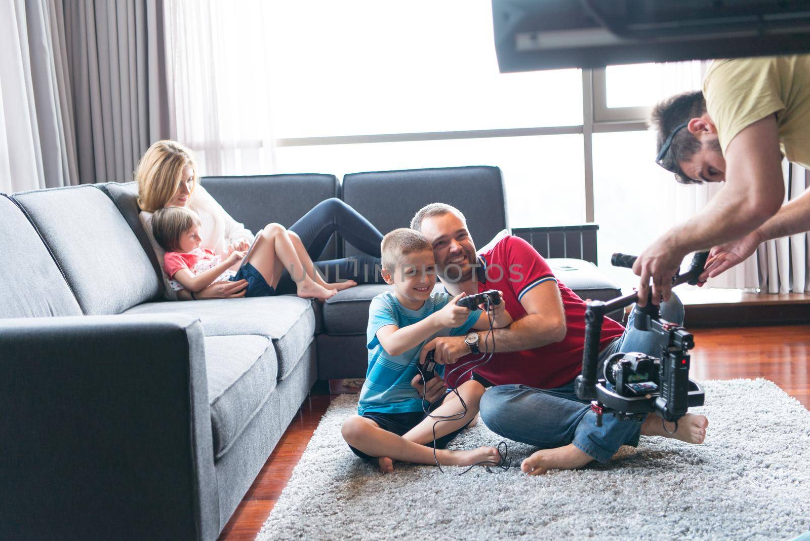 Happy family. Father, mother and children playing a video game Father and son playing video games together on the floor