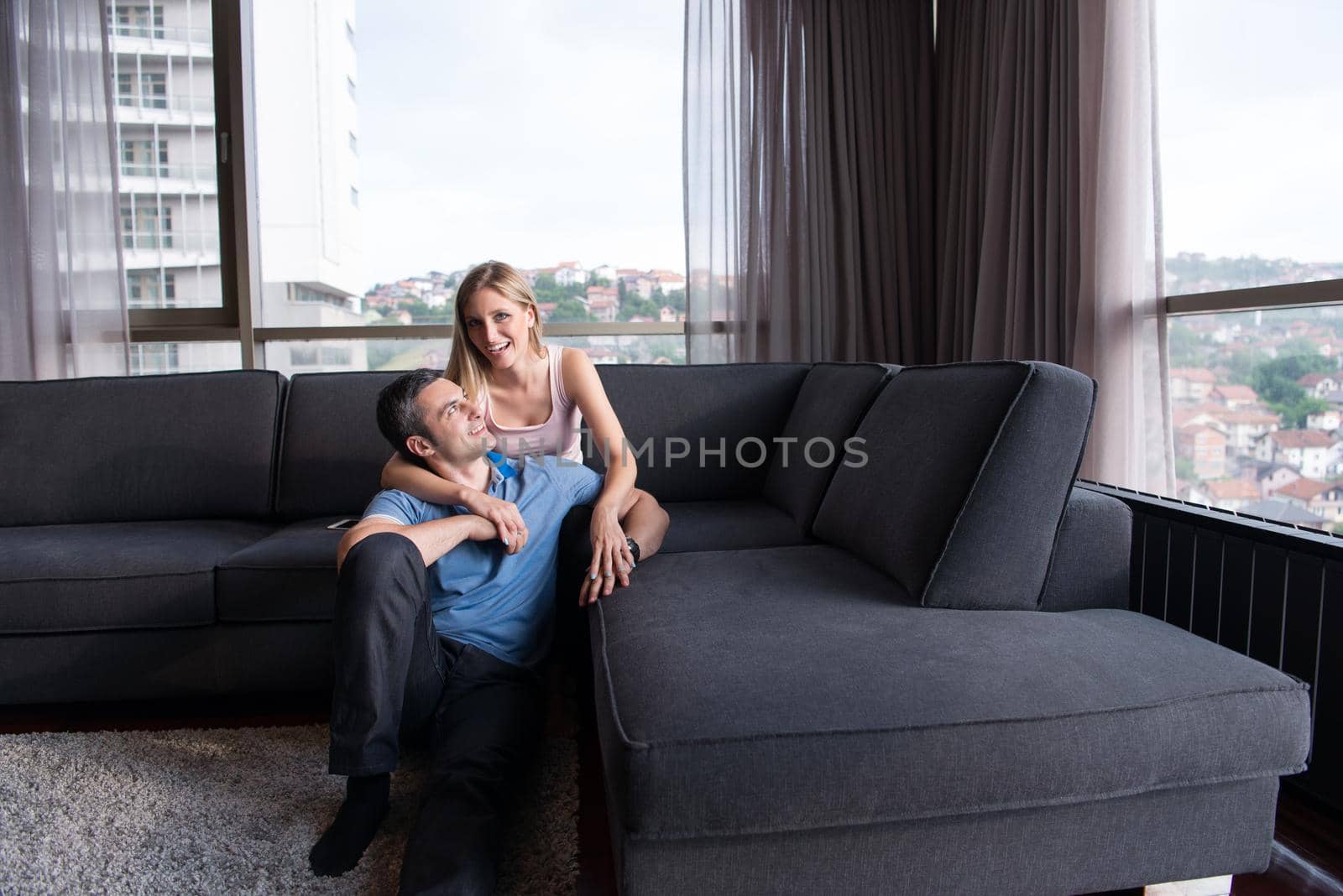 young handsome couple hugging on the sofa by dotshock