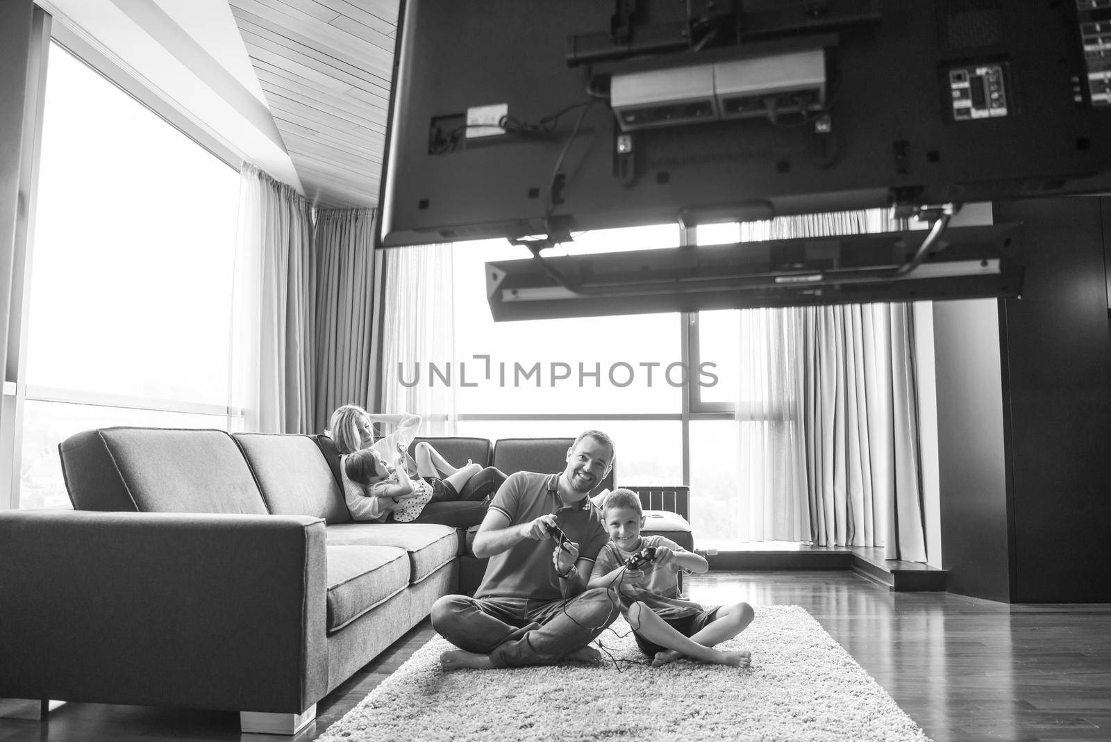 Happy family. Father, mother and children playing a video game Father and son playing video games together on the floor