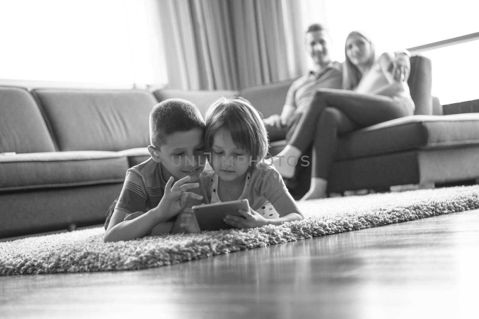 Happy Young Family Playing Together at home.kids using tablet on the floor