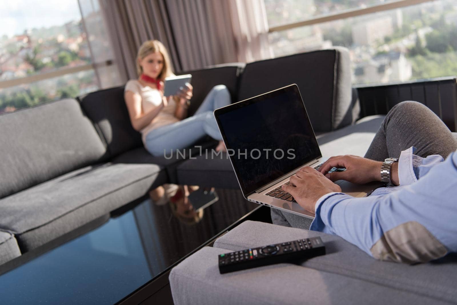 couple relaxing at  home using tablet and laptop computers by dotshock
