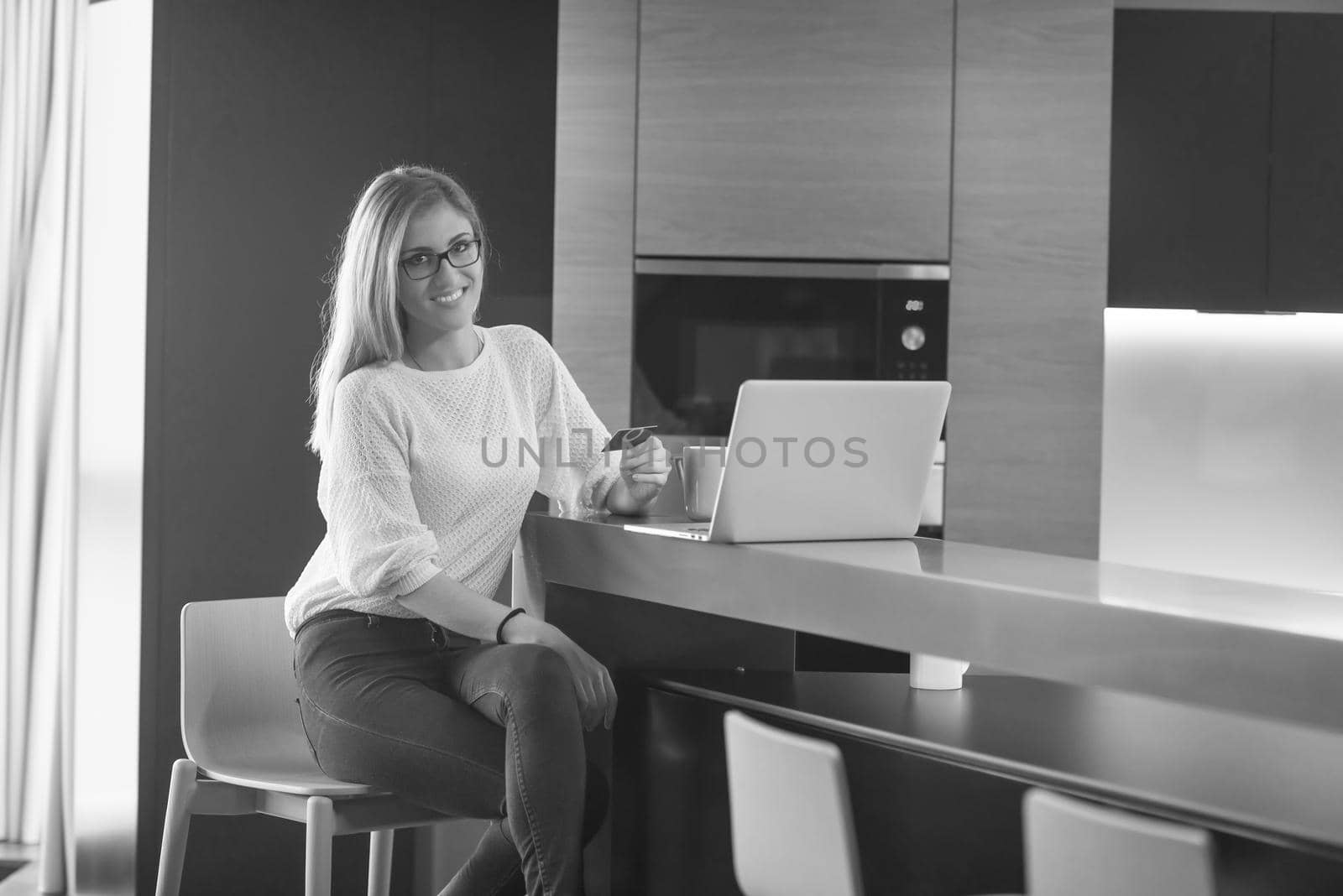 Young woman holding credit card and using laptop computer. Online shopping concept