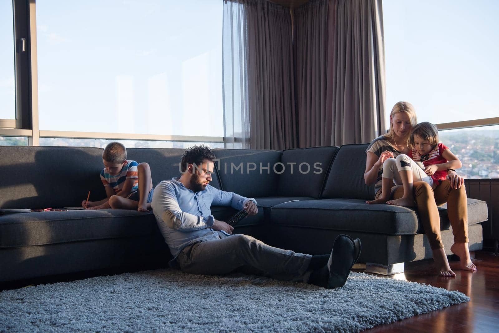 Happy Young Family Playing Together on sofa by dotshock