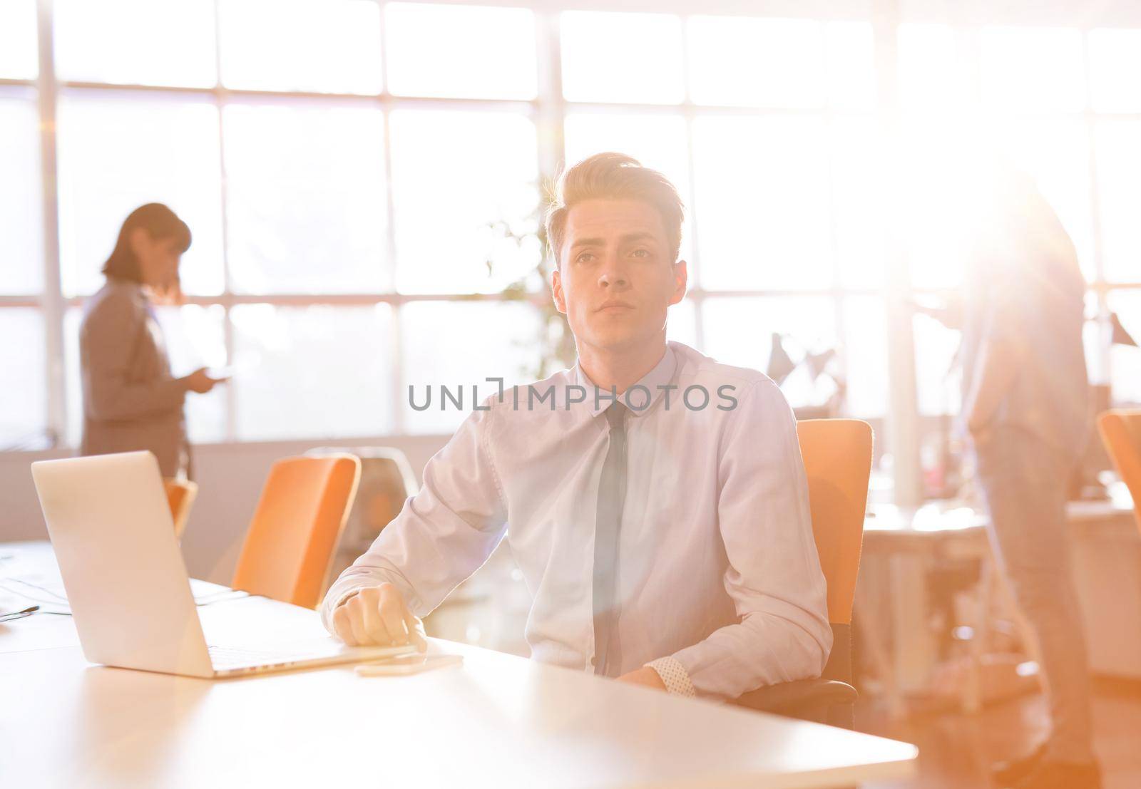 Young businessman using computer at work by dotshock