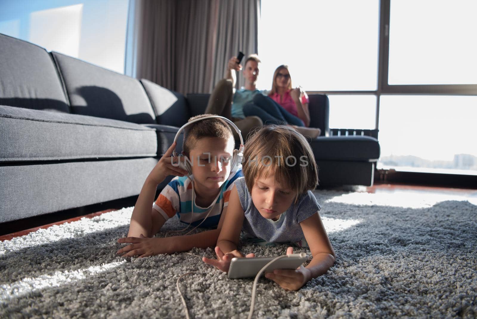 Happy Young Family Playing Together at home.kids using tablet on the floor
