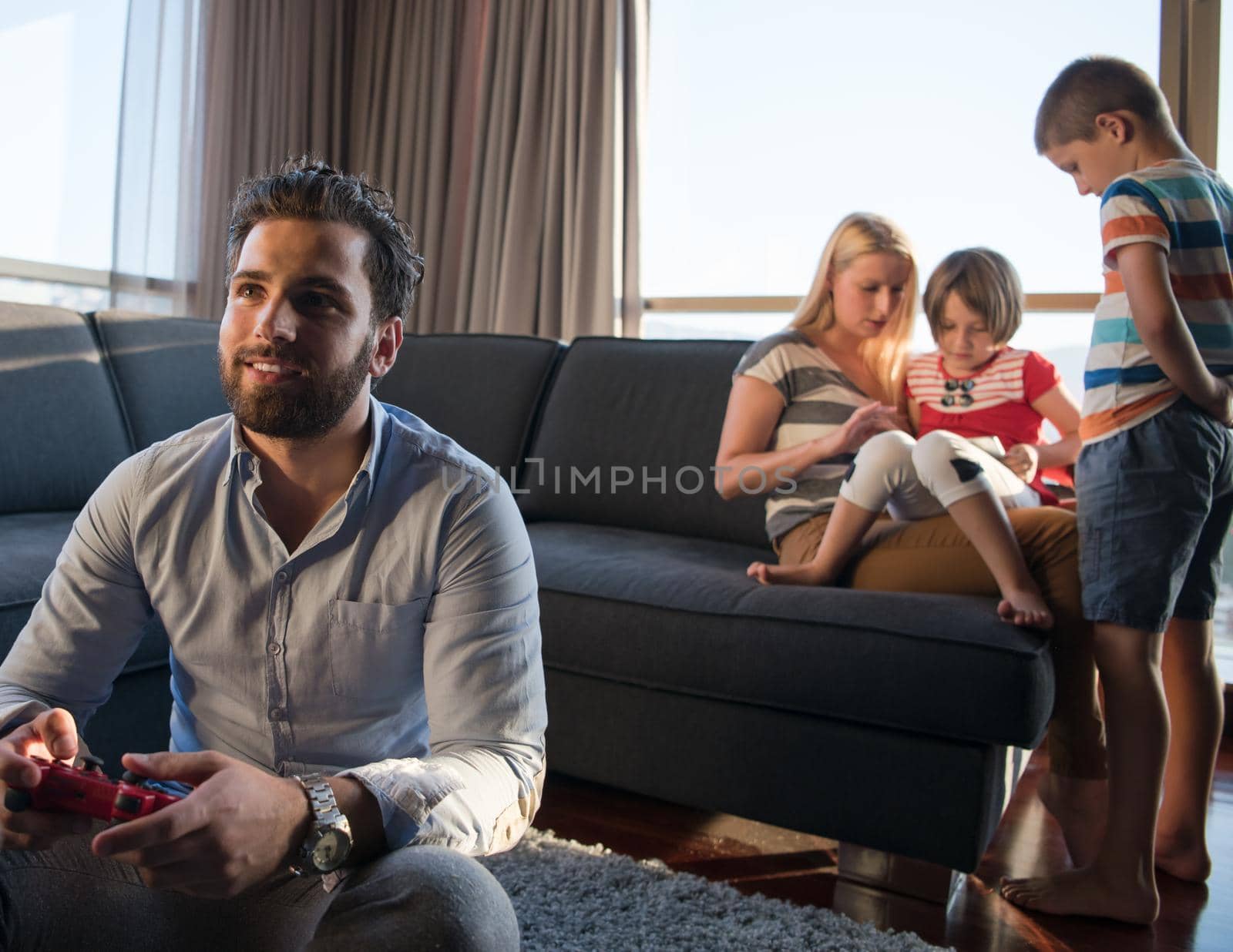 Happy family. Father, mother and children playing a video game Father and son playing video games together on the floor