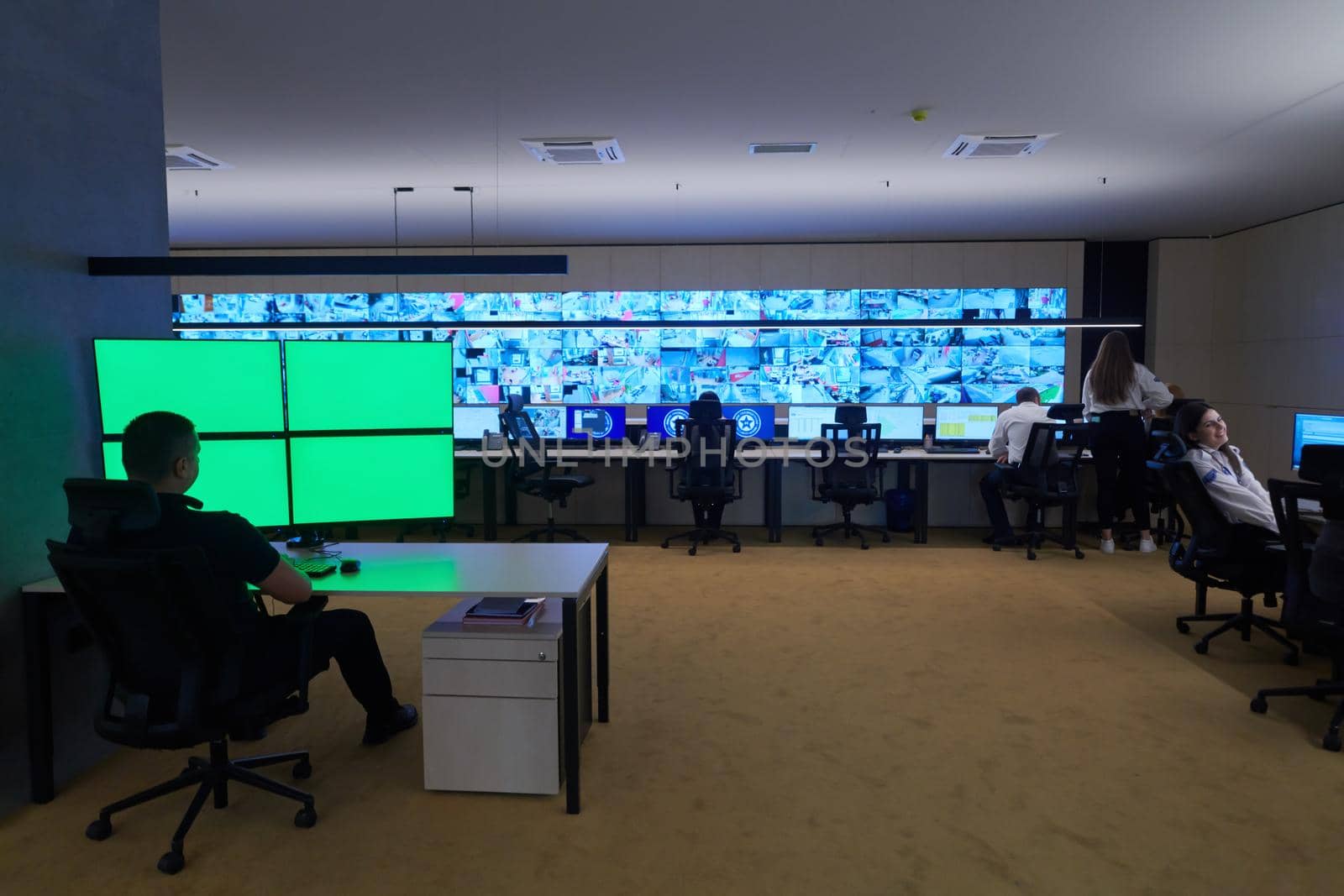 Group of Security data center operators working in a CCTV monitoring room looking on multiple monitors  Officers Monitoring Multiple Screens for Suspicious Activities  Team working on the System Control Room