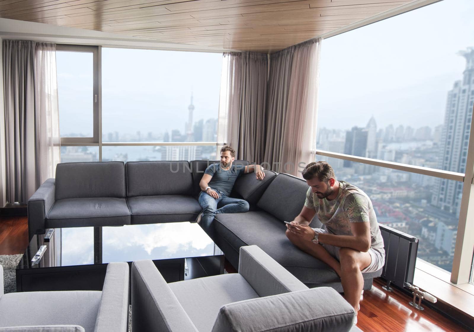 Handsome casual young men using a mobile phones  near the window at home