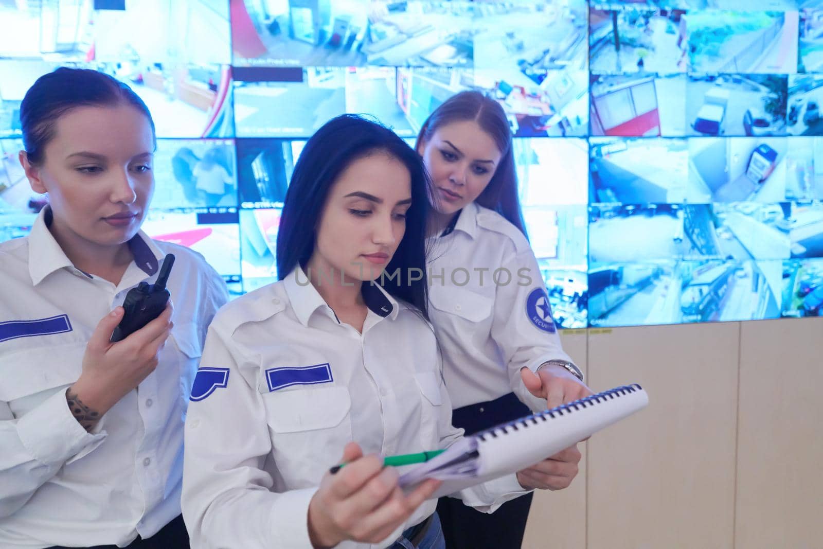 Female security guards working in a security data system control room by dotshock