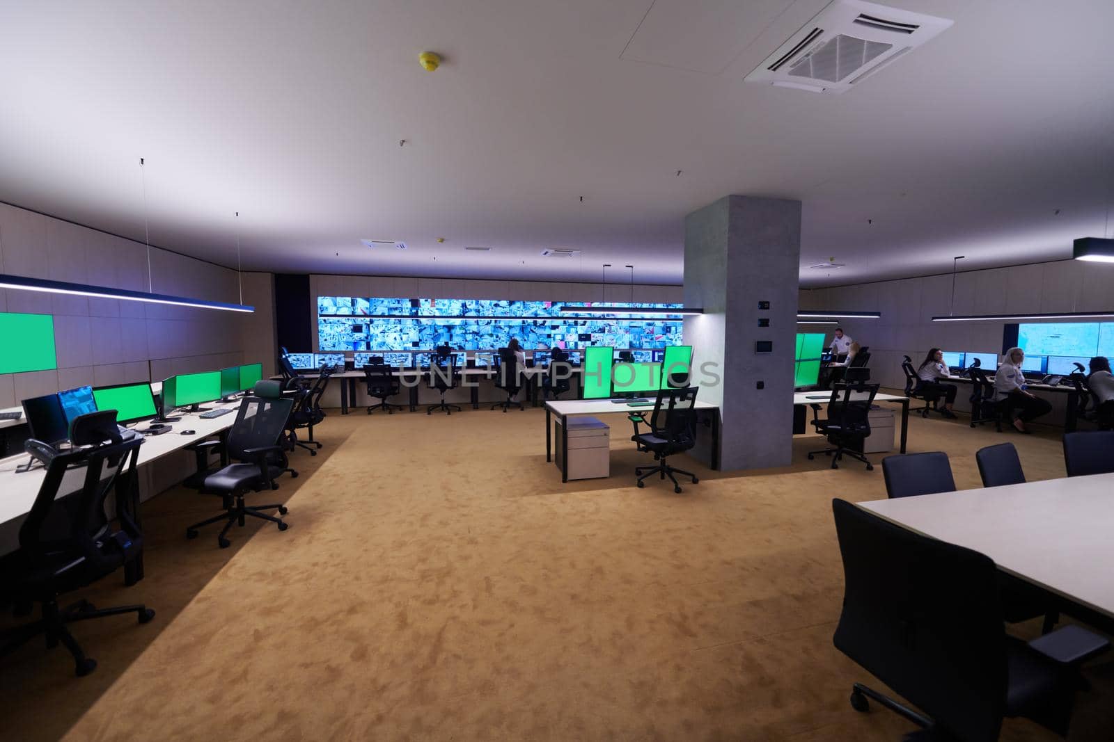 Group of Security data center operators working in a CCTV monitoring room looking on multiple monitors  Officers Monitoring Multiple Screens for Suspicious Activities  Team working on the System Control Room