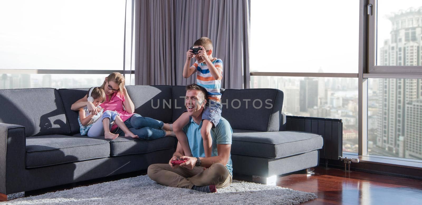 Happy family. Father, mother and children playing a video game Father and son playing video games together on the floor