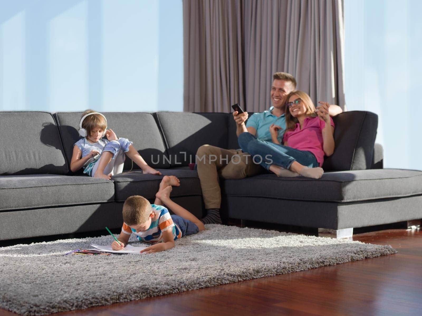 Happy Young Family Playing Together at home using a tablet and a children's drawing set