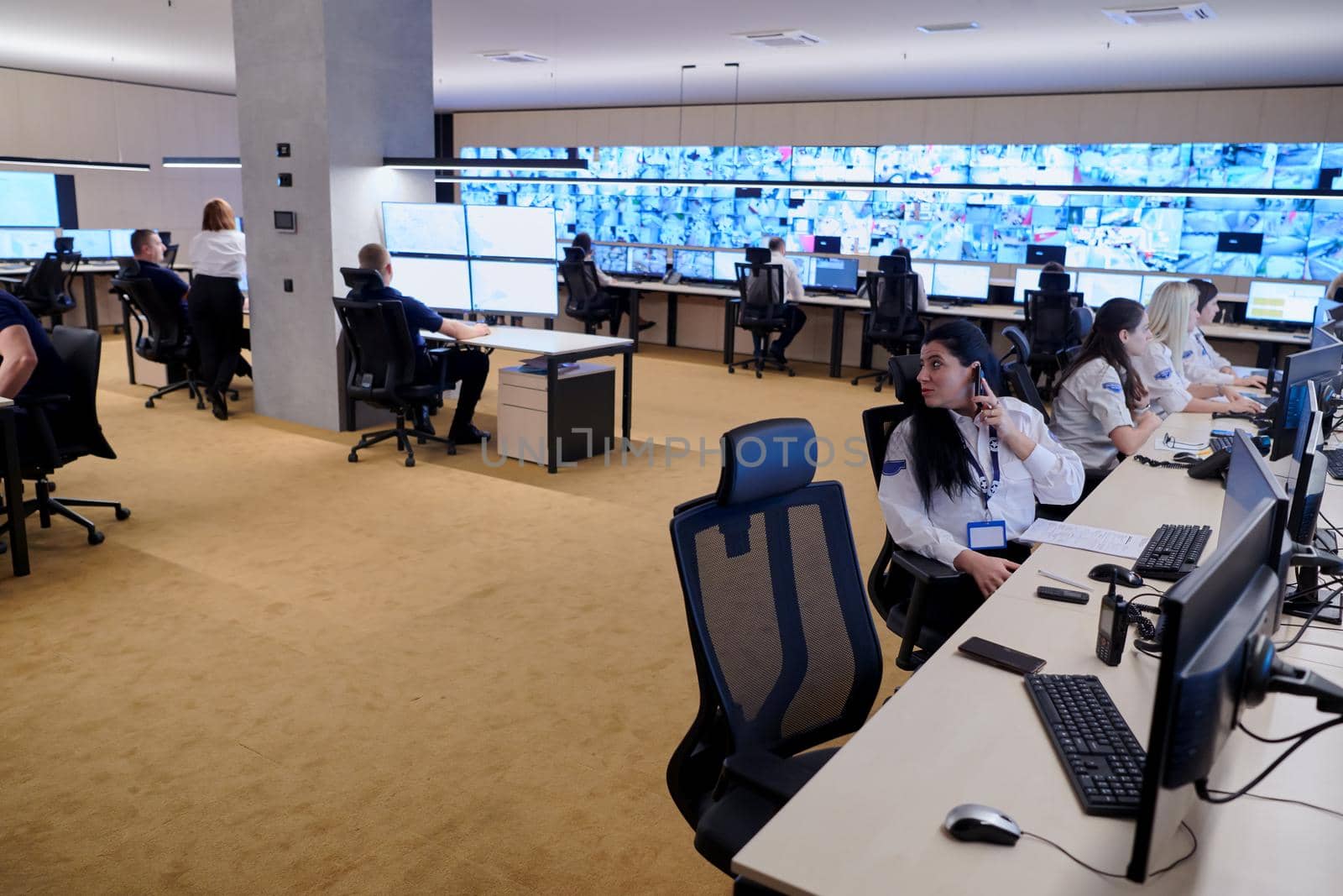 Group of Security data center operators working in a CCTV monitoring room looking on multiple monitors  Officers Monitoring Multiple Screens for Suspicious Activities  Team working on the System Control Room