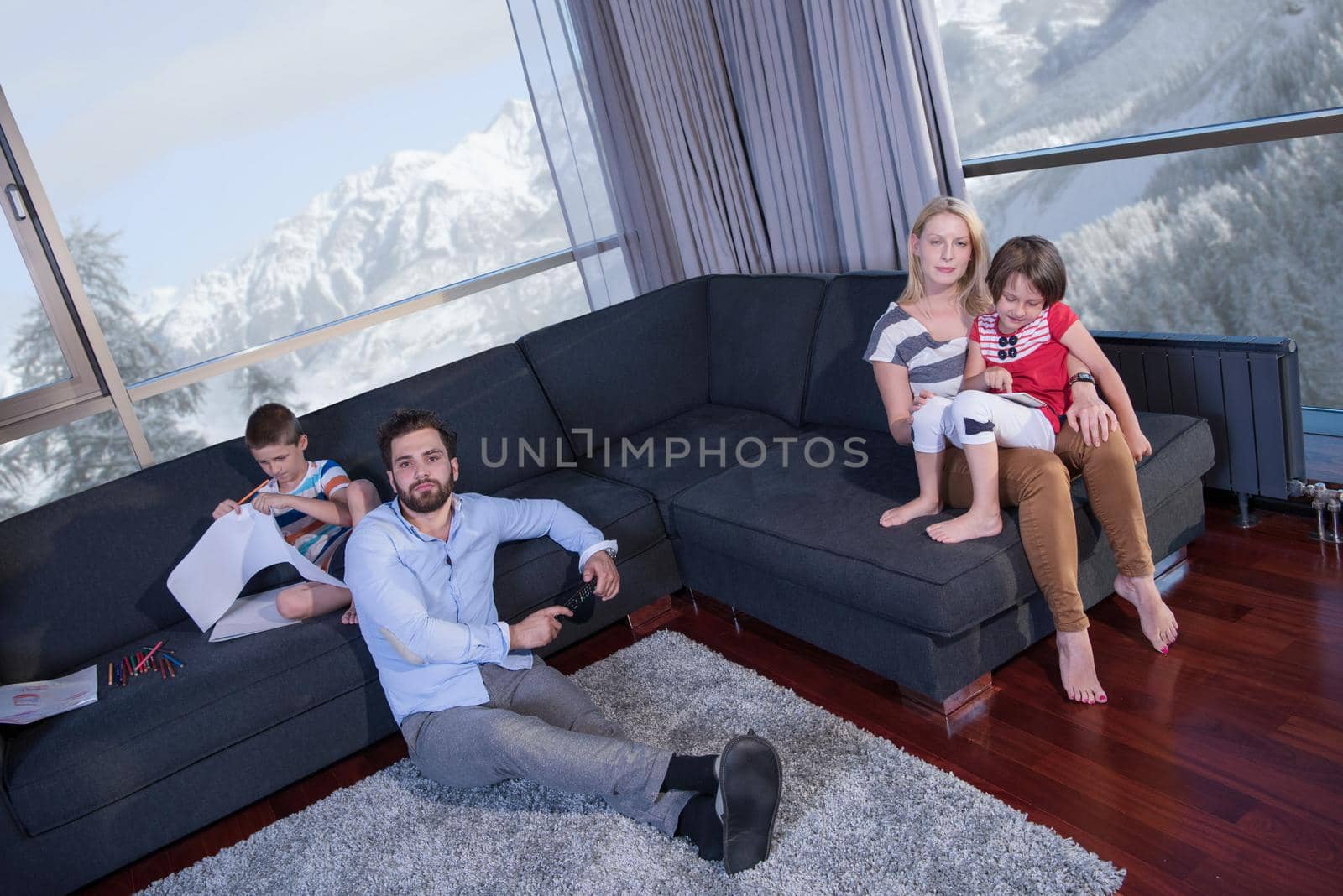 Happy Young Family Playing Together on sofa at home using a tablet and a children's drawing set