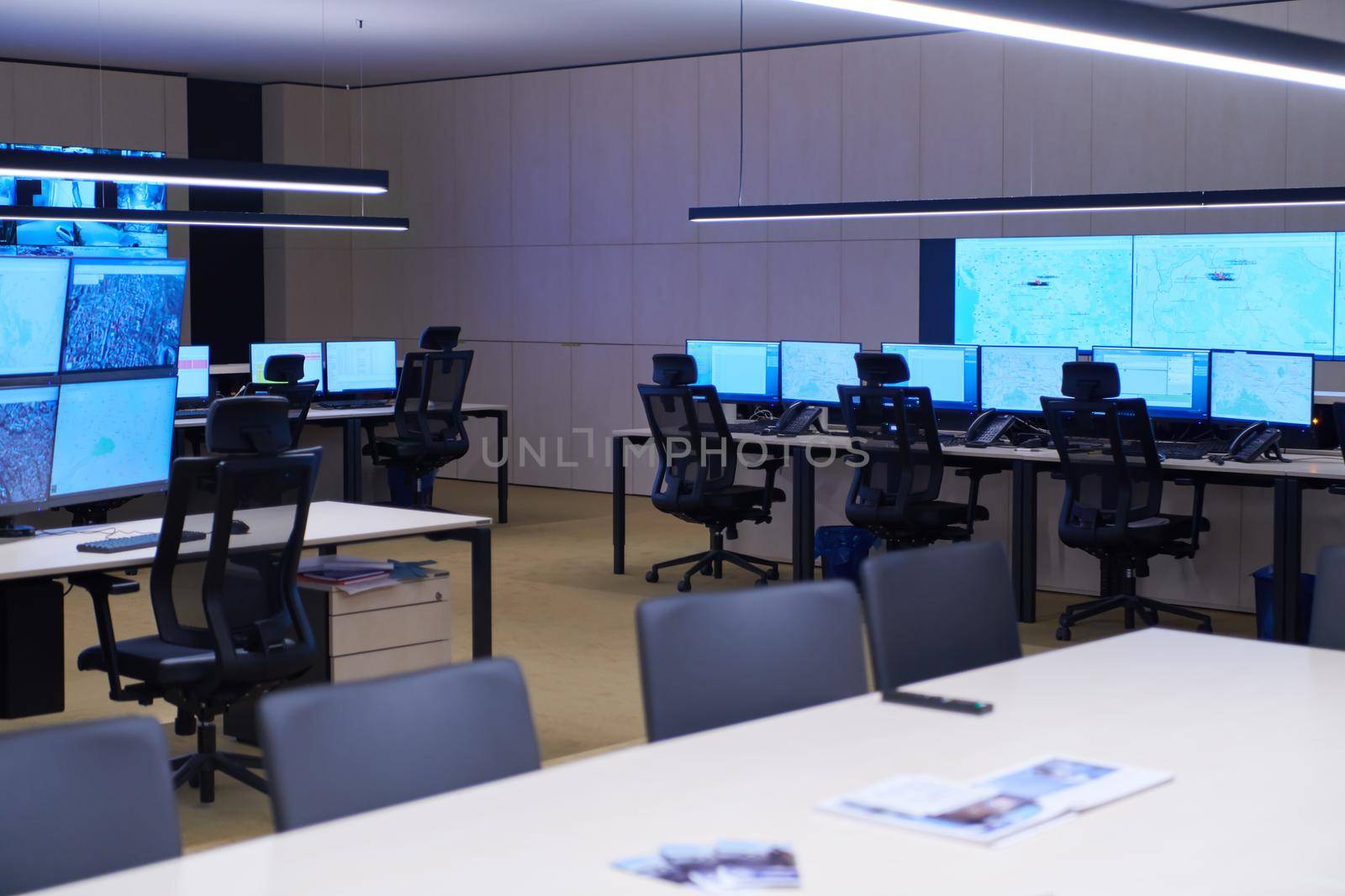 Empty interior of big modern security system control room, workstation with multiple displays, monitoring room with at security data center  Empty office, desk, and chairs at a main CCTV security data center