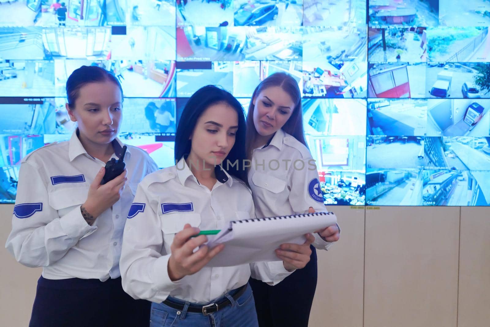 group of female security operators working in a data system control room  Technical Operators Working at  workstation with multiple displays, security guards working on multiple monitors in surveillance room, monitoring cctv and discussing
