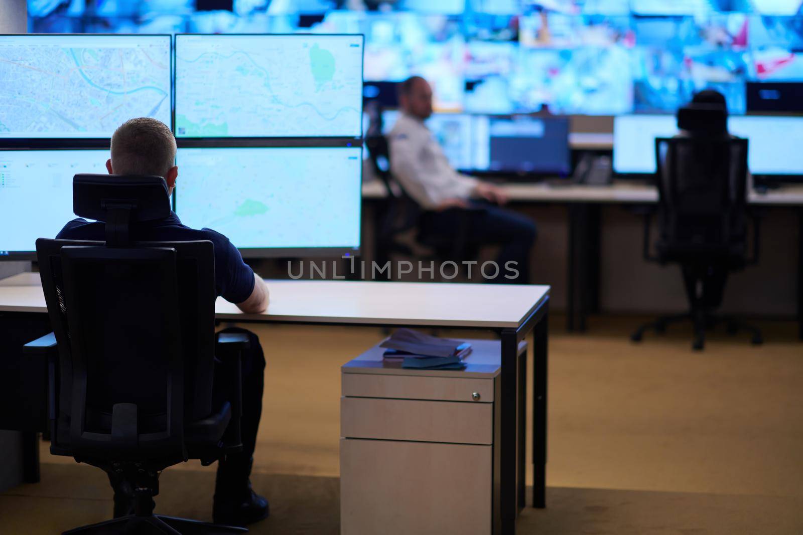 Male security operator working in a data system control room offices Technical Operator Working at  workstation with multiple displays, security guard working on multiple monitors  Male computer operator monitoring from a security center