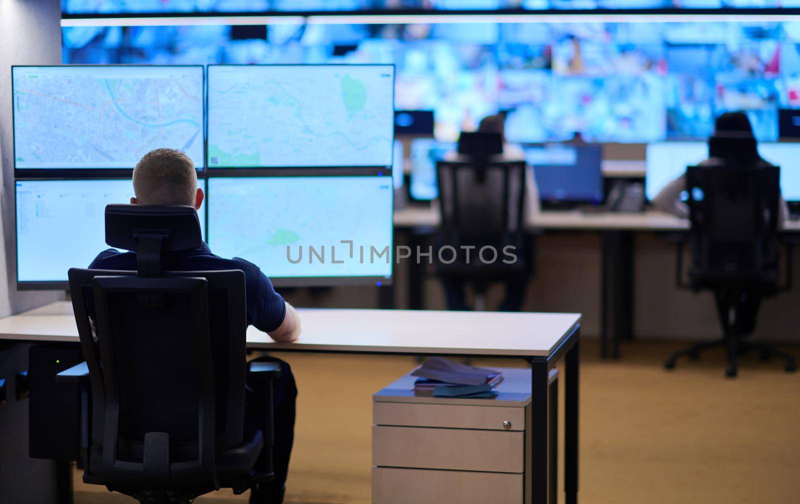 Male security operator working in a data system control room offices Technical Operator Working at  workstation with multiple displays, security guard working on multiple monitors  Male computer operator monitoring from a security center