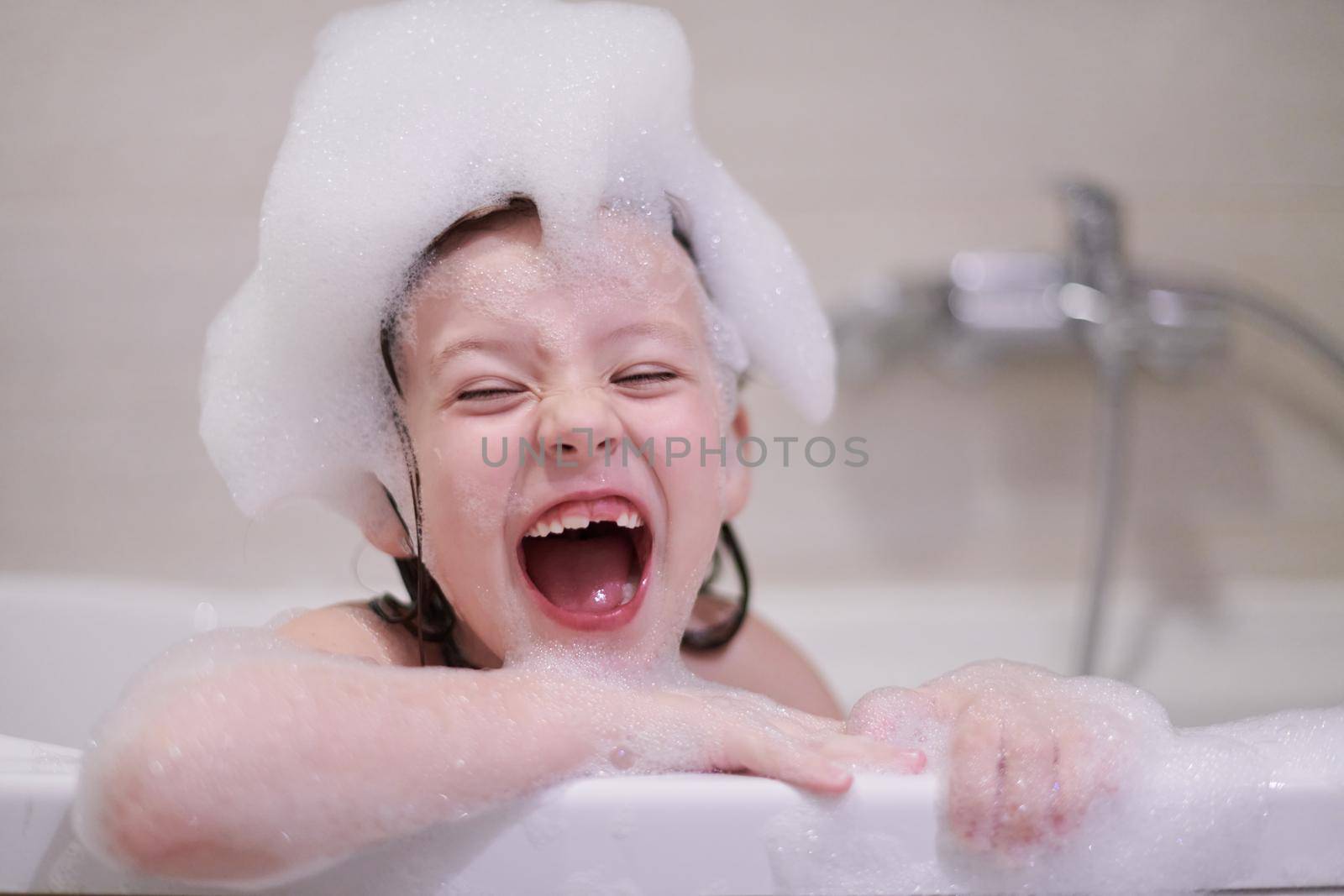 little girl in bath playing with soap foam by dotshock