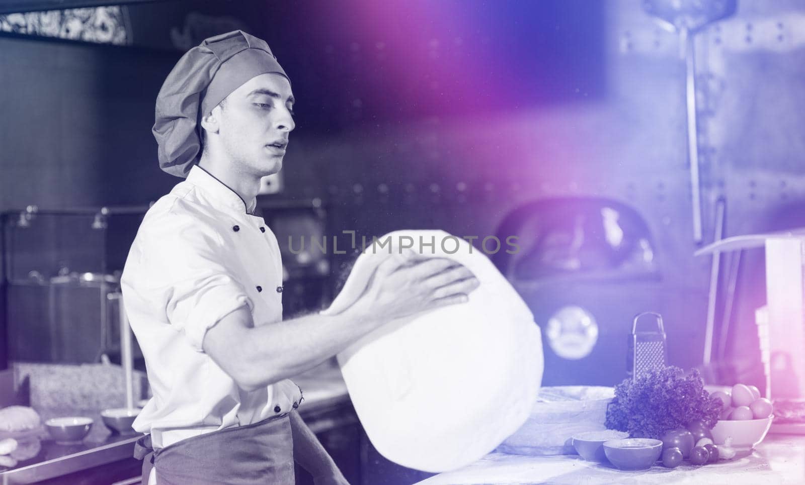 Skilled chef preparing dough for pizza rolling with hands and throwing up