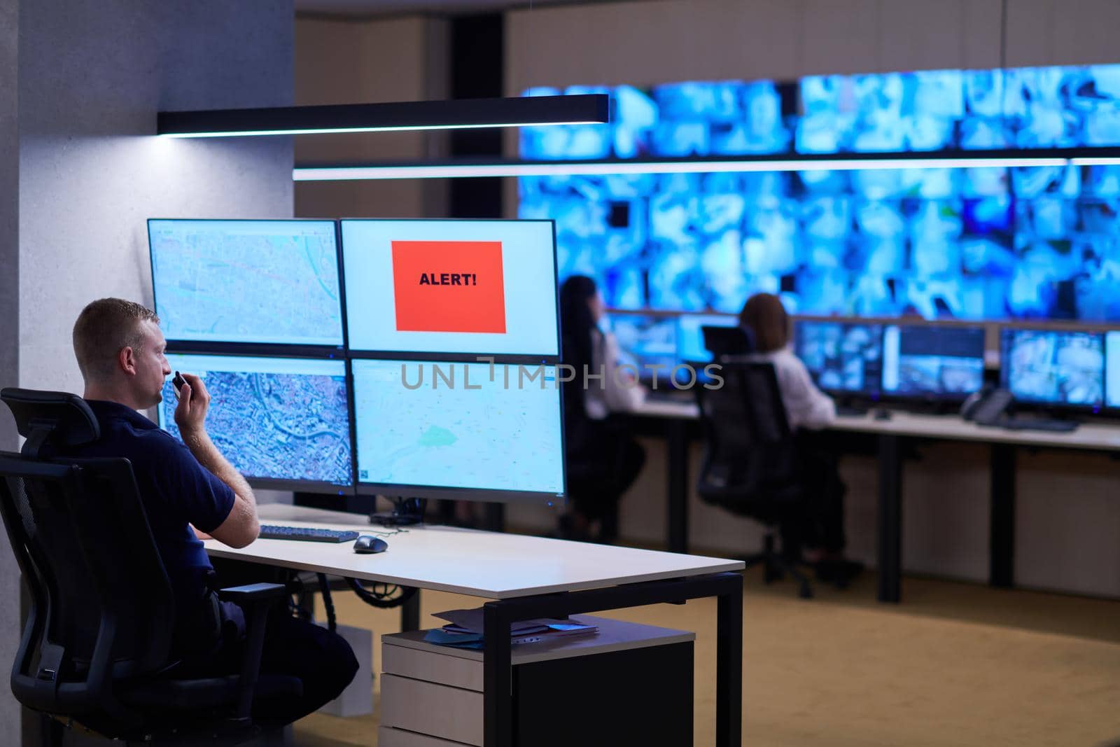 Male security operator working in a data system control room offices Technical Operator Working at  workstation with multiple displays, security guard working on multiple monitors  Male computer operator monitoring from a security center Alarm signal on the screen