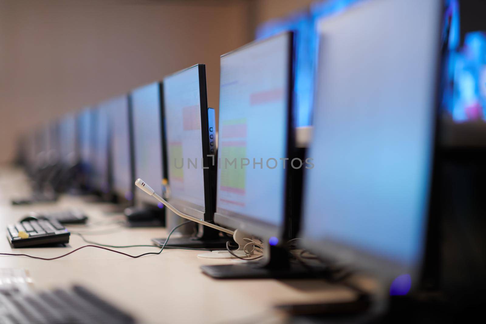 Empty interior of big modern security system control room, workstation with multiple displays, monitoring room with at security data center  Empty office, desk, and chairs at a main CCTV security data center