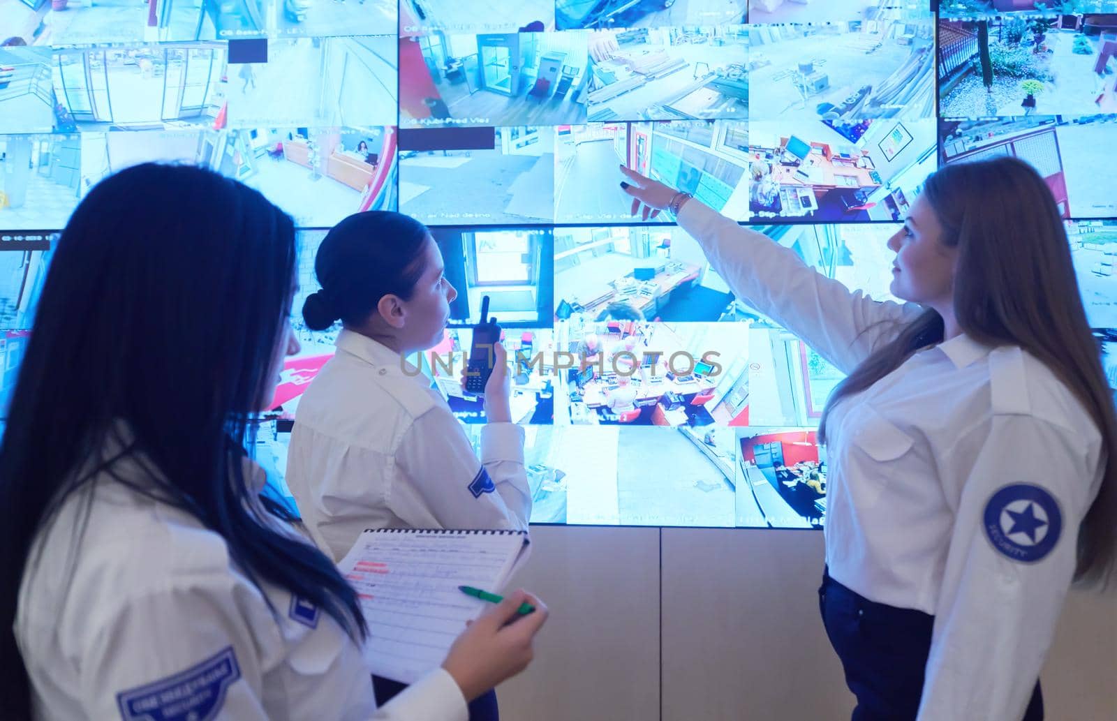 group of female security operators working in a data system control room  Technical Operators Working at  workstation with multiple displays, security guards working on multiple monitors in surveillance room, monitoring cctv and discussing
