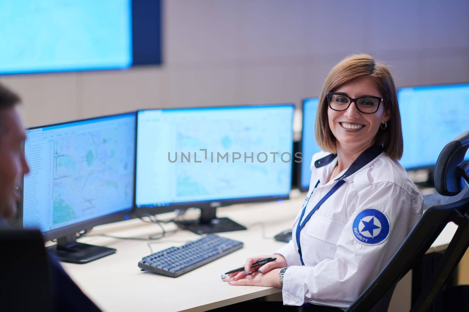 portrait of female security operator while working in a data system control room offices Technical Operator Working at  workstation with multiple displays, security guard working on multiple monitors