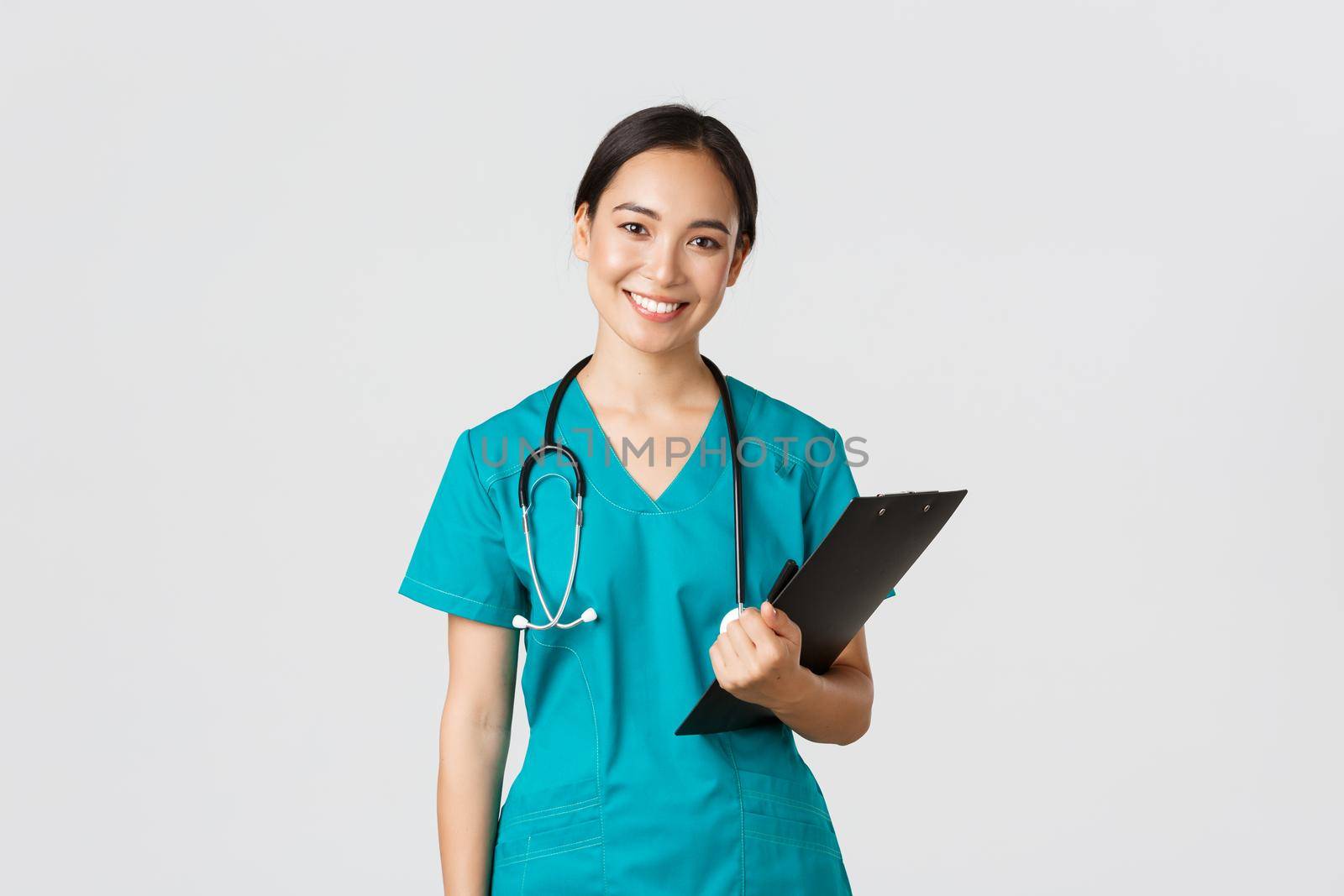 Healthcare workers, preventing virus, quarantine campaign concept. Smiling asian female nurse, doctor with clipboard wearing scrubs, provide checkup, examine patient in clinic, white background.