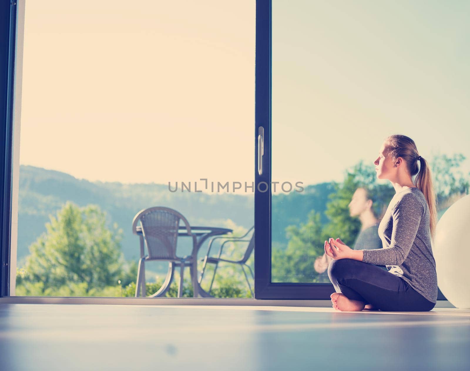 young woman doing morning yoga exercises by dotshock