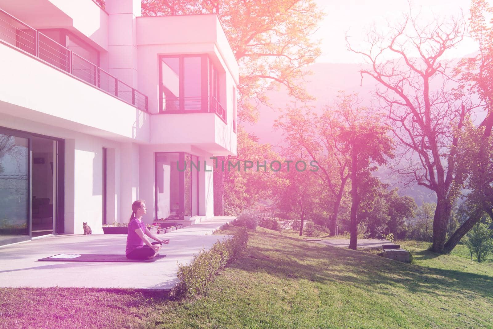 handsome woman doing morning yoga exercises in front of her luxury home villa