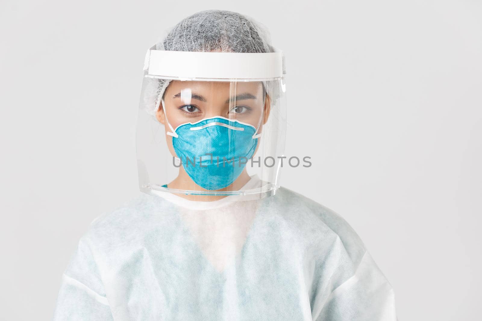 Covid-19, coronavirus disease, healthcare workers concept. Close-up of confident serious-looking female tech lab employee, doctor in personal protective equipment, respirator and face shield.